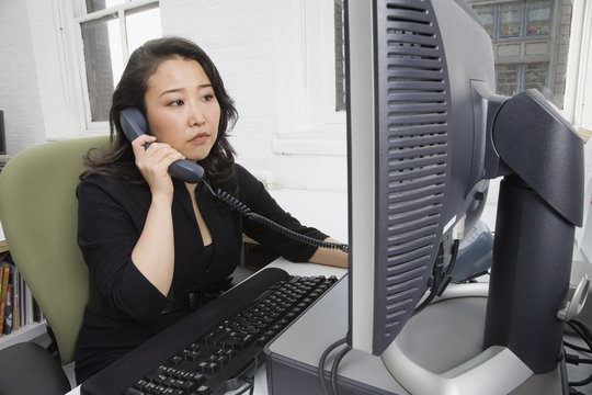 Asian businesswoman talking on telephone