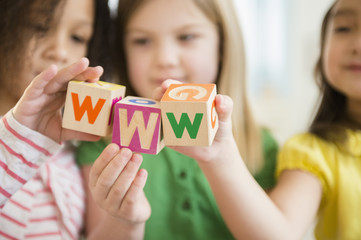 Girls holding colorful 'w' blocks
