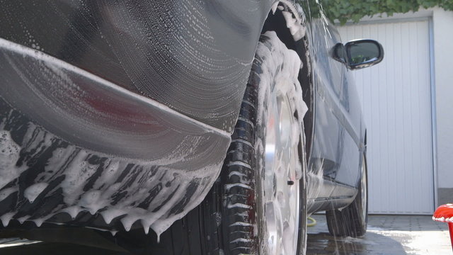 Washing a car using a sponge and a bucket - sliding camera