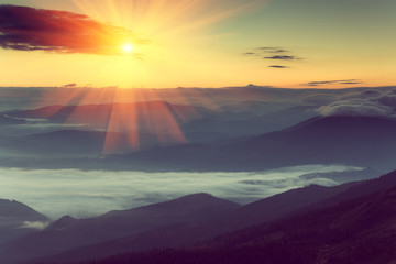 Majestic sunrise in the foggy mountain layers landscape.