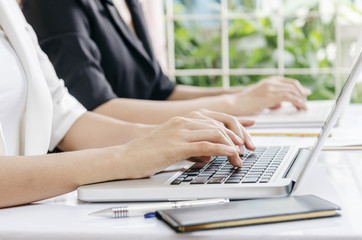 two business workers typing data in laptop