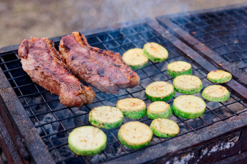 Meat and zuccini slices on grill