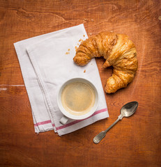 Rural breakfast with cup of coffee and croissants.