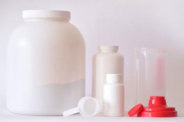 Big jar of protein powder, bottles and shaker