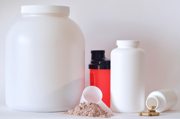 Big jar of protein powder, shaker, pills and tablets