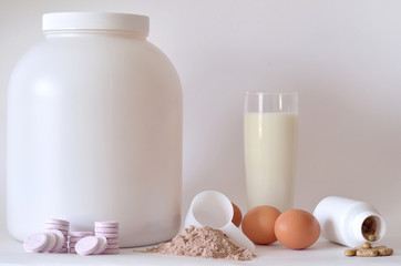 Big jar of protein powder, bottles, milk, pills and tablets