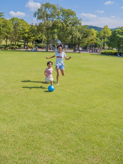 芝生広場でボール遊びする姉妹