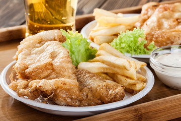 Fish and chips with tartar sauce on a tray