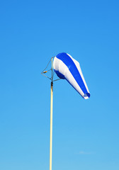 Blue windsock against sky background.