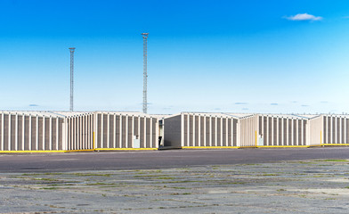 Outdoor view of many warehouses over blue sky.