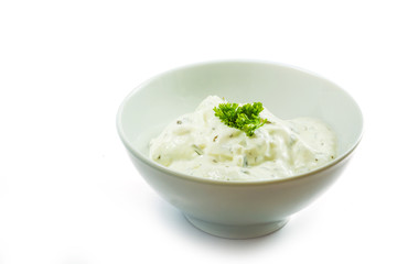 cream cheese dip with herbs in a ceramic bowl isolated on white