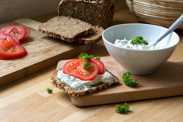 curd cheese dip with herbs and rustic wholegrain bread with toma