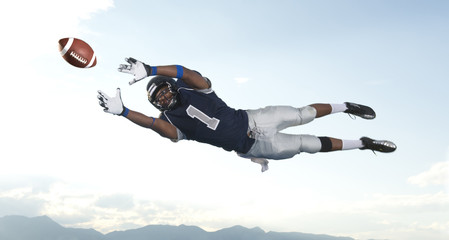 African American football player catching ball