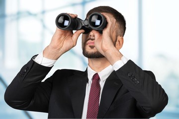 Man. Young businessman looking with binoculars