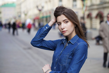 Portrait of a beautiful young woman in a blue jeans shirt on the