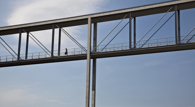 Woman walking on skybridge, Berlin, Germany