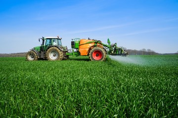 Naklejka premium Ackerbau, Pflanzenschutz - auf einem Getreidefeld wird gespritzt