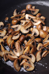 Fried sliced mushrooms in butter in a frying pan