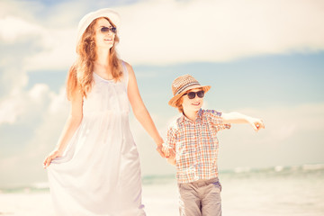 Fototapeta na wymiar Happy beautiful mother and son enjoying beach time