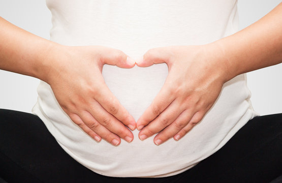 Pregnant Belly with fingers Heart symbol.(Clipping path)