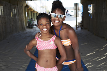 Black girls in bikinis smiling outdoors