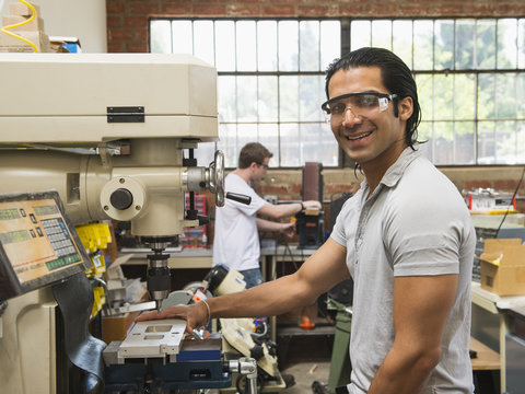 Workers using machinery in machine shop
