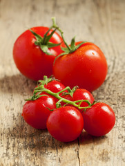 fresh red tomatoes with drops of water on wooden table, selectiv
