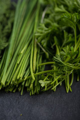 Spring garden fresh chives,parsley and dill on black slate  back