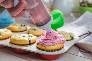 Obraz na płótnie Canvas Decorating sweet cupcakes with sweet cream