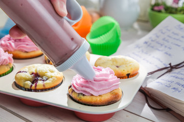 Decorating sweet cupcakes with cream
