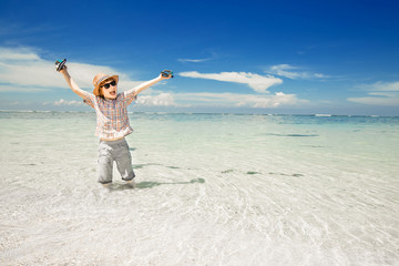 Happy young boy staying in the ocean water on beautiful beach