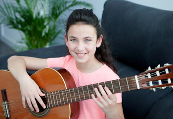 Young girl playing a guitar at home