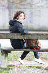 Young student sitting on a bench at park/campus