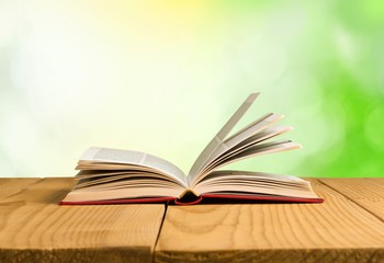 Book. Open book on wood planks over abstract light background