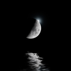 Backlit moon with white star over water