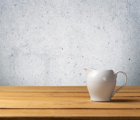 Dressing. White gravy boat on wooden table over grunge