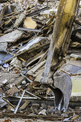 excavator bucket and ruins of the old brick building