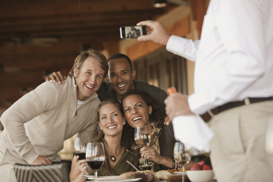 Man taking photographs of friends in restaurant