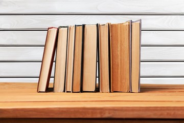 Book. Vintage books on wooden table over retro wallpaper