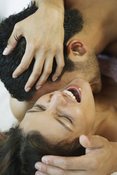 Hispanic man kissing wife's neck