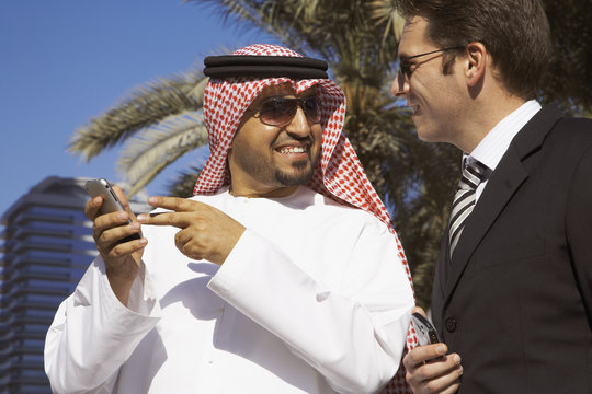 Multi-ethnic businessmen holding cell phones