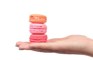 Tasty colorful macaroons in female hand isolated on white
