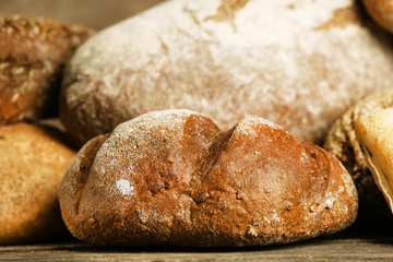 Different fresh bread on old wooden table