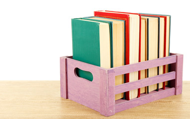 Books in wooden box isolated on white