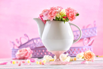 Obraz na płótnie Canvas Composition with beautiful spring flowers in teapot on light pink background