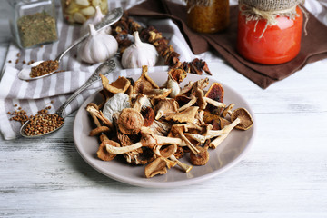 Dried mushrooms in plate on wooden background