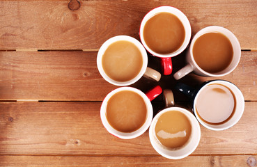 Cups of cappuccino on wooden table, top view