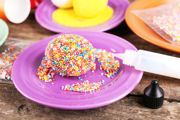 Decoration Easter eggs with colorful beads on wooden table, closeup