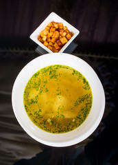Chicken soup in white plate and crackers
