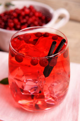 Compote with red currant in glassware on wooden table, closeup